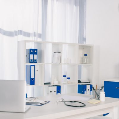 laptop and stethoscope at working table in clinic